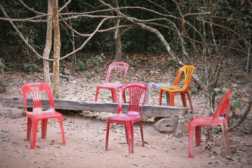 A circle of mostly empty plastic chairs after a meeting
